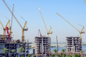 Naklejka premium residential buildings under construction with cranes at construction site