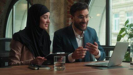 Arabian business colleagues two coworkers girl guy office employees male female muslim hijab woman man talk video call laptop online conference happy businessman businesswoman showing financial graph - Powered by Adobe