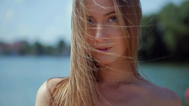 young woman in a bikini walks on the sunny beach. A girl with elastic buttocks is sunbathing on the beach. The charming thin model poses to the camera. Woman in bikini relaxing on sandy beach. Beauty 