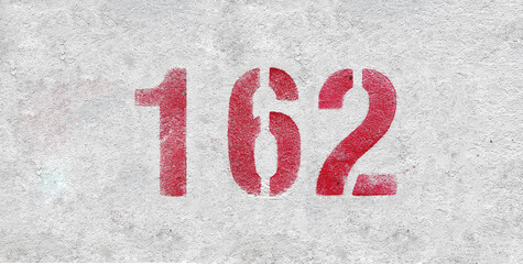 Red Number 162 on the white wall. Spray paint.