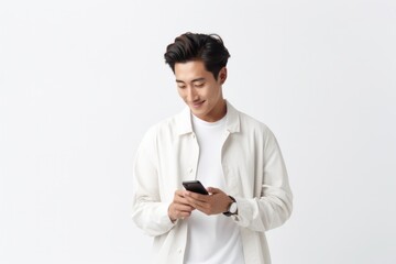 Handsome Asian young man using mobile phone Surf the web or social media sitting on an armchair on holiday relax