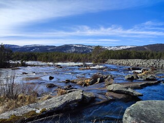 Mountain river with fast flowing water. View of scandinavian mountains