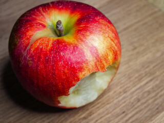 Apple and Wood. An apple with a bite mark, on wood, perfect for illustrating healthy lifestyle or natural food choices.