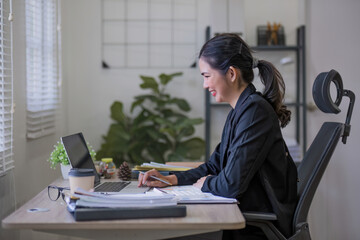 Portrait Of Attractive Asian Businesswoman Working On Laptop for marketing plan