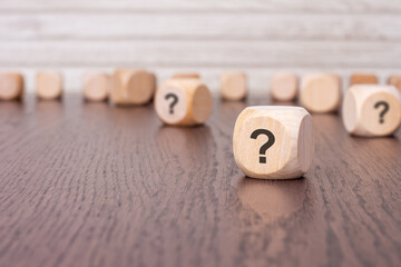 question mark cube stand on wooden background with copy space.