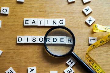 magnifying glass on the words EATING DISORDER and measuring tape