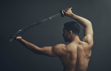 Back view, ninja and samurai sword in studio for training, wellness and fitness with martial arts. Blade, exercise and warrior by black background for karate, fight and battle for dojo in Japan © Lumeez23/peopleimages.com