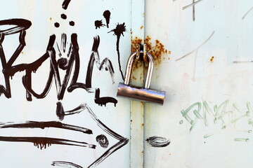 An old metal lock hangs on the fence.