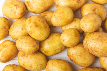 Young potatoes. Fresh potatoes  on a wooden background.Harvesting collection. organic, freshly dug potatoes. Agricultural background. Vegan. Vegetables.Place for text.Copy space