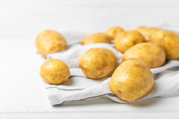 Young potatoes. Fresh potatoes  on a wooden background.Harvesting collection. organic, freshly dug potatoes. Agricultural background. Vegan. Vegetables.Place for text.Copy space