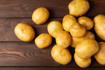 Young potatoes. Fresh potatoes  on a wooden background.Harvesting collection. organic, freshly dug potatoes. Agricultural background. Vegan. Vegetables.Place for text.Copy space