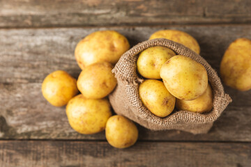 Young potatoes. Fresh potatoes  on a wooden background.Harvesting collection. organic, freshly dug potatoes. Agricultural background. Vegan. Vegetables.Place for text.Copy space