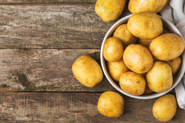 Young potatoes. Fresh potatoes on a wooden background.Harvesting collection. organic, freshly dug potatoes. Agricultural background. Vegan. Vegetables.Place for text.Copy space