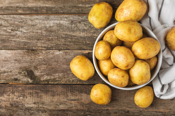 Young potatoes. Fresh potatoes  on a wooden background.Harvesting collection. organic, freshly dug potatoes. Agricultural background. Vegan. Vegetables.Place for text.Copy space