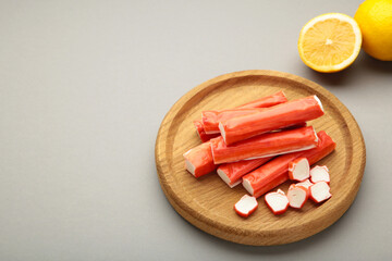 Cut crab sticks in bowl on grey background. Space for text