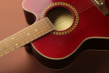 Obraz premium Detail of red guitar on brown background. Space for text