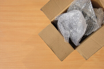 open box with air bubble packaging on the table. place for text. packaging and delivery concept