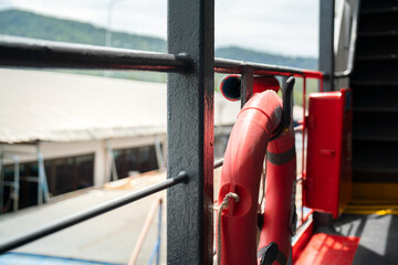 A rescue lifebuoy which is installed on ship corridor rail, stand by for people overboard into the sea. Emergency equipment for transportation object photo. Selective focus.