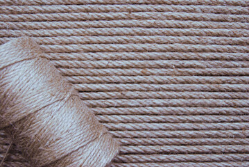 a spool of hemp rope on a background of jute rope