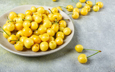yellow cherry, cherry berry, scattered on a plate, top view, no people,