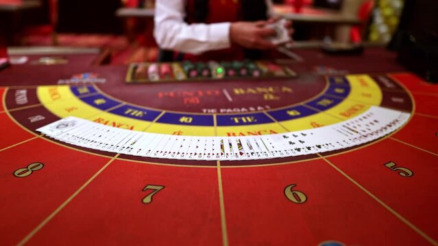 The dealer spreads the cards on a casino table three times. Point and bank. Blackjack, Poker, Baccarat. Close-up. Slow motion