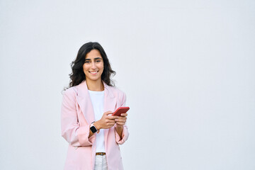 Indian or arabic woman in business suit holding cellphone, looking at camera. Happy young middle eastern businesswoman using smartphone mobile phone for work isolated on white background. Copy space