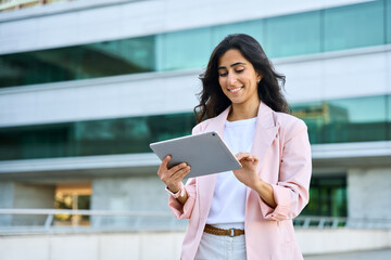 Smiling young middle eastern Israel businesswoman using tablet pc application for online remote...