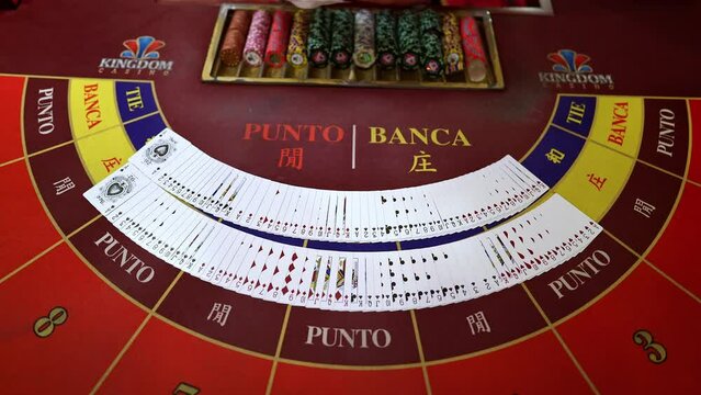 The dealer spreads the cards on a casino table three times. Point and bank. Blackjack, Poker, Baccarat. Zenithal angle.