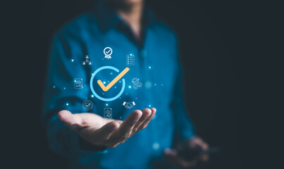 Businessman holding a digital icon of a checkmark with quality assurance and certification symbols, standard compliance and guarantee. quality control, automation process, Standardization, certified,