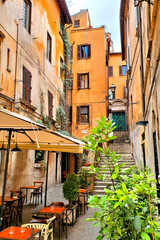 Obraz premium Quaint restaurant in the colorful narrow lanes of historic Rome, Italy