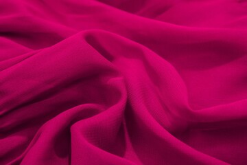 Close-up of vibrant magenta fabric with soft folds and texture