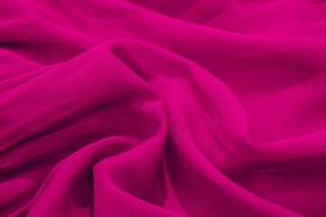Close-up of vibrant magenta fabric with soft folds and texture