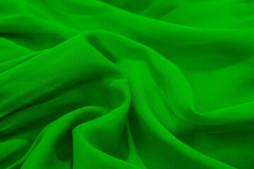 Close-up of vibrant green fabric with soft folds and texture