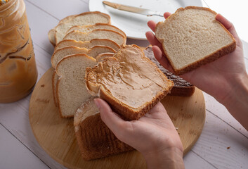 Concept of taking or grabbing food with hands, feminine Mexican hands. Slices of bread on a white...