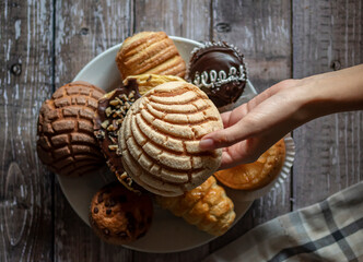 Concept of taking or grabbing food with hands, feminine Mexican hands. Traditional Mexican bakery,...