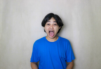 portrait of a very attractive random handsome Asian Indonesian man on a white isolated background wearing blue clothes