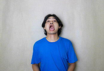 portrait of a very attractive random handsome Asian Indonesian man on a white isolated background wearing blue clothes