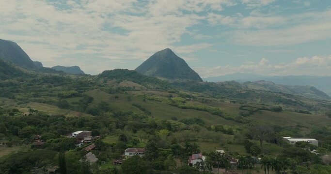 rising shot of tropical scenery with large pyramid volcano in background far from drone in colombia cerro tusa