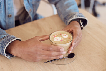 Hands, relax and man in coffee shop, cafe and customer with weekend break, caffeine product and calm. Closeup, person and guy with cappuccino, espresso and retail with store, client or chai tea latte