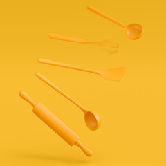 Wooden kitchen utensils, tools and equipment on yellow monochrome background.