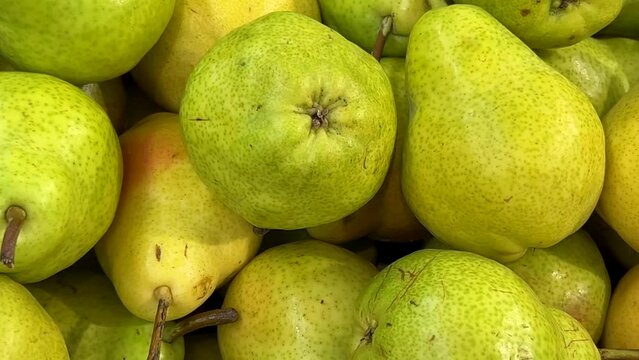 Ripe pears in top view, tracking shot on yellow pears displayed on fruit stand