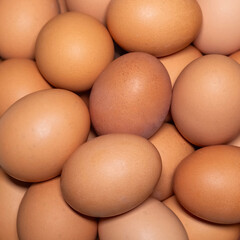 Stack of brown eggs on square format.