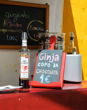 Obidos, Portugal - April 30, 2015: Local specialty - traditional Ginja sour cherry liqueur - proposed  for tourists for drinking in chocolate cups during famous chocolate festival. 