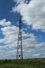 A power line tower in a grassy field