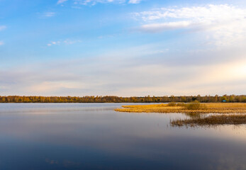 A lake with a cloudy sky in the background