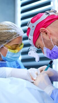 Focused medic work on the surgery in modern hospital. Surgeon operates the patient for thyroid eye disease. Vertical video.
