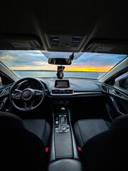 Interior View of Car Overlooking a Serene Lakeside at Sunset: A Perfect Blend of Modern Comfort and Natural Beauty