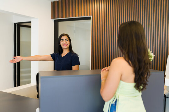 Receptionist offering a warm welcome to a customer at the modern beauty clinic, demonstrating outstanding customer care