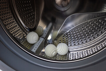 Three wash balls in an empty washing machine tub. Eco-friendly household concept. Selective focus, copy space