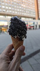 Eis mit Lakritze und Waffel in der Hand
